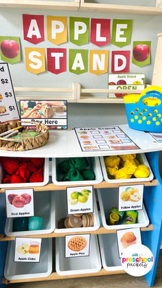 an apple stand with several bins filled with apples and other items on the table