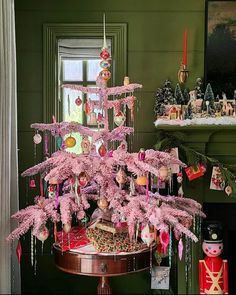 a pink christmas tree with ornaments hanging from it