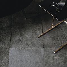 a black table sitting on top of a floor next to a chair