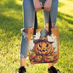 a woman is holding a trick or treat bag in her hands while standing on the grass