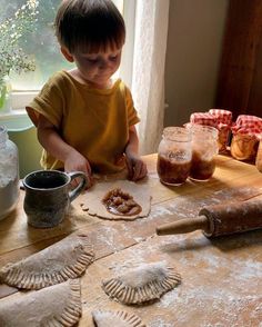 a young boy making homemade pastries on a table