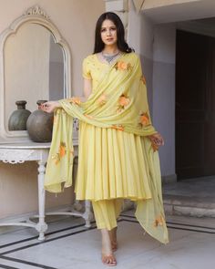 This is a beautiful 3 piece anarkali suit set.The set includes anarkali style kurta has round neck, short sleeves & calf length.It also comes with solid pants with semi elasticated waistband and a hand painted dupatta with and tassels and lace detailing. Suit Fabric-Mul Cotton Dupatta Fabric-Chiffon Length-Calf Length Color - Yellow Neck-Round Neck Sleeves-3/4th sleeves Washing Care-Dry Clean or Quick Deep Wash DISCLAIMER - The color of the product may be differ due to screen settings of device. Anarkali Sharara With Traditional Drape For Summer, Summer Anarkali Set With Zari Work, Straight Kurta, Summer Anarkali Georgette Kurta, Summer Anarkali Set With Chikankari Embroidery, Summer Anarkali Sharara In Georgette, Summer Anarkali Salwar Kameez With Self Design, Summer Anarkali Salwar Kameez With Pallu, Semi-stitched Anarkali For Summer, Summer Anarkali Set With Straight Kurta