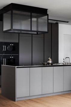 a modern kitchen with black and white cabinets, stainless steel appliances and an island in the middle