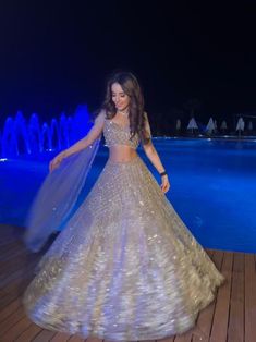 This lehenga set is hand embroidered with all-over sequin, crystal, and cutdana work on a nude gold net base. Paired with a crystal-embellished cold shoulder blouse with tassel detailing and an attached drape.DELIVERY TIMEPlease allow 8-12 weeks for your outfit to arrive.FABRIC DETAILSNetProfessional cleaning only. Glamorous Organza Choli For Reception, Glamorous Wedding Dress For Diwali, Navratri Reception Gown With Sequins, Sequin Gown For Reception And Navratri, Glamorous Organza Lehenga For Reception, Glamorous Dresses With Dupatta For Festivals, Glamorous Semi-stitched Dress With Sheer Dupatta, Glamorous Organza Choli With Dupatta, Glamorous Reception Organza Lehenga