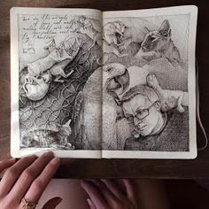 a person holding an open book with drawings on it