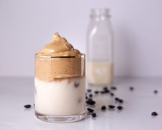 a glass jar filled with whipped cream and chocolate chips next to a bottle of milk