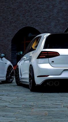 two white cars parked next to each other