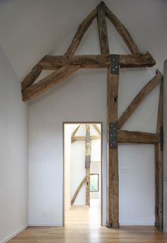 an empty room with wooden beams and white walls