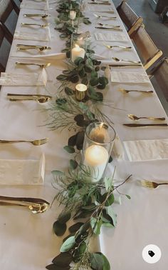 a long table is set with candles and greenery for an elegant dinner or party