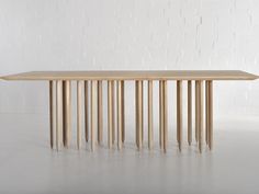 a table made out of wooden sticks with white brick wall in the backround