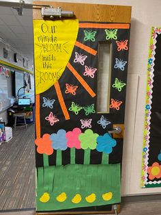 a classroom door decorated with flowers and butterflies