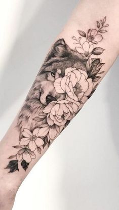 a wolf and flowers tattoo on the arm