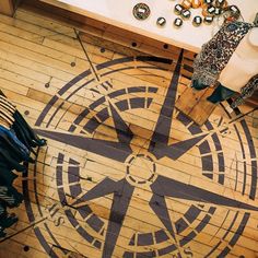 an overhead view of a wooden floor with a compass design on it