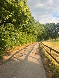 an empty country road surrounded by trees and grass