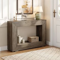 a wooden table with a basket and candle on it in front of a door way