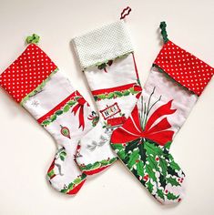 three christmas stockings hanging on a white table with polka dots and green trimmings