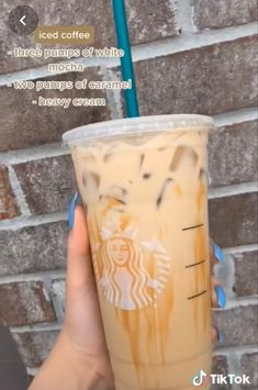 someone holding up a starbucks drink in front of a brick wall with an instagram message