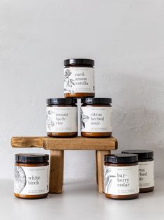 six jars of honey sit on a wooden stand