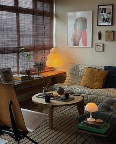 a living room filled with furniture next to a window covered in shades of brown and yellow