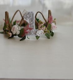 a flower crown with the number one on it is sitting on a white countertop