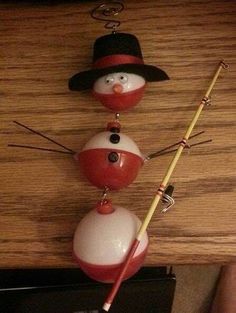 two snowmen are hanging on the wall with fishing rods