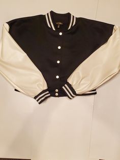 Vibe Check Long Sleeves Short Cut Jacket with front buttons. Has white and black trim around the bottom of the sleeves.