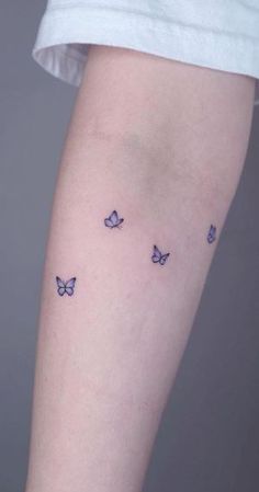 a woman's arm with butterflies tattoo on the left side of her leg,