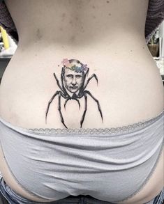 a woman's stomach with a spider tattoo on her belly and an image of the man