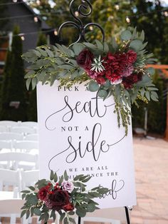 a sign that says pick a seat not a side with flowers and greenery on it