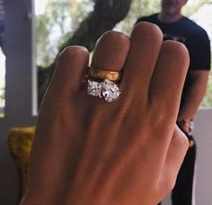 a man wearing a gold and white ring with two diamonds on it's finger