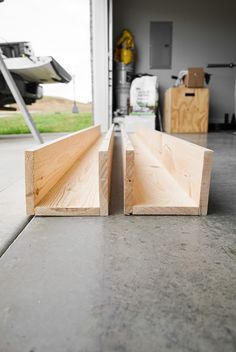 two pieces of wood sitting on top of a cement floor