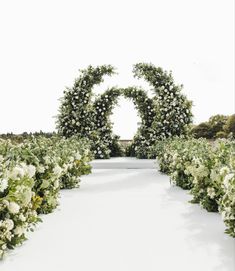 an outdoor ceremony with white flowers and greenery