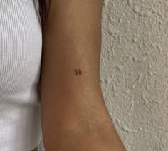 a woman's arm with a small tattoo on the left side of her arm