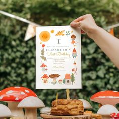 a person holding up a card in front of some mushrooms and other things on the table