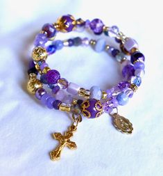 This sparkling purple/lilac/lavender floral bracelet is made of super strength German wrapping wire. Filled with gorgeous gold-plated accents that just makes the purple shades pop! 3-strand Memory wire Gold-plated tiny crucifix Gold-plated tiny Miraculous medal. Handmade Bracelets Tutorial, Heirloom Christmas, Jewelry Stack, Super Strength, Purple Shades, Lavender Floral, Floral Bracelet, Lilac Lavender, Purple Jewelry