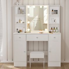 a white dressing table with lights on it