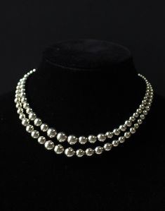 This is an exquisite vintage Monet double-stranded silver beaded choker necklace. The elegant piece features a Monet signed tag. With an adjustable length ranging from 15 to 17 inches, it is in excellent vintage condition. I do not routinely pack in gift boxes to prevent excess waste. Your item will be in a clear plastic baggie and securely padded for transport.   I am not a professional jewelry expert, and the information provided in this listing is based on my best knowledge and research. The vintage piece(s) you are considering is being sold as-is, and I encourage you to carefully review the detailed photos provided in the listing.  Important Points to Note:  Condition: The item is sold in its current condition, and any imperfections or wear are accurately represented in the listing pho Classic Silver Pearl Necklace For Party, Classic Silver Double Strand Necklace, Vintage Silver Pearl Necklace For Party, Elegant Adjustable Polished Beads Choker, Vintage Silver Pearl Necklace For Evening, Silver Double Strand Necklaces For Evening, Silver Double Strand Necklace For Evening, Silver Vintage Beaded Choker, Classic Silver Multi-strand Necklace