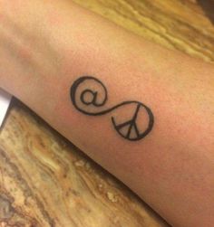 a person's arm with a peace sign tattoo on the left side of their arm