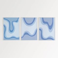 three abstract paintings hang on the wall next to each other