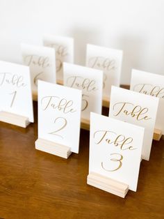 place cards with gold numbers on them sitting on a table