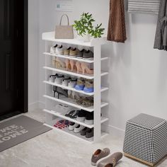 a white shoe rack filled with shoes next to a black and white rug on the floor