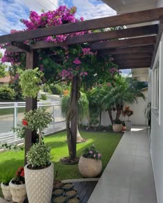 some potted plants are on the side of a house's front porch area