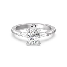 a white gold engagement ring with an oval cut diamond and baguets on the side