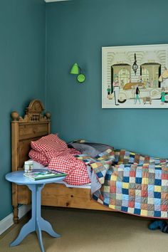 a bed room with a neatly made bed and a painting on the wall