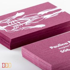 two purple business cards sitting on top of each other