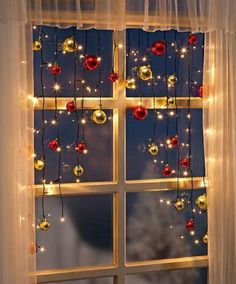 the window is decorated with christmas lights and ornaments