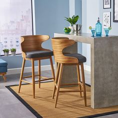 two wooden stools sitting next to a counter in a room with blue walls and pictures on the wall