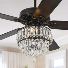 a ceiling fan with crystal chandelier hanging from it's blades in a living room