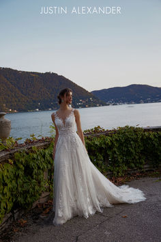 a woman in a wedding dress standing by the water