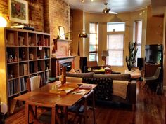 a living room filled with furniture and a fire place next to a book shelf full of books